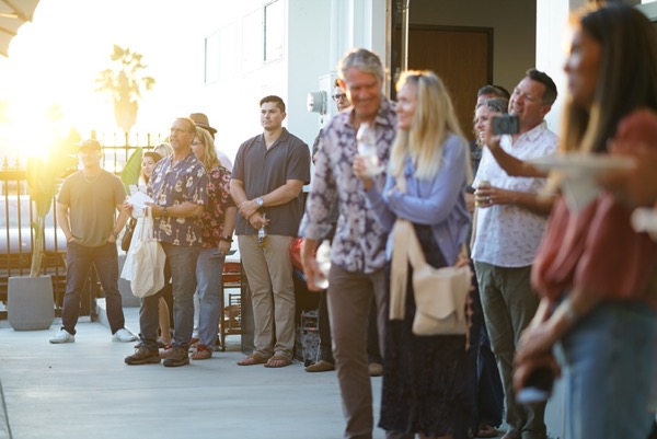 Friends and neighbors gathered outside the Petrol Club in the late afternoon light