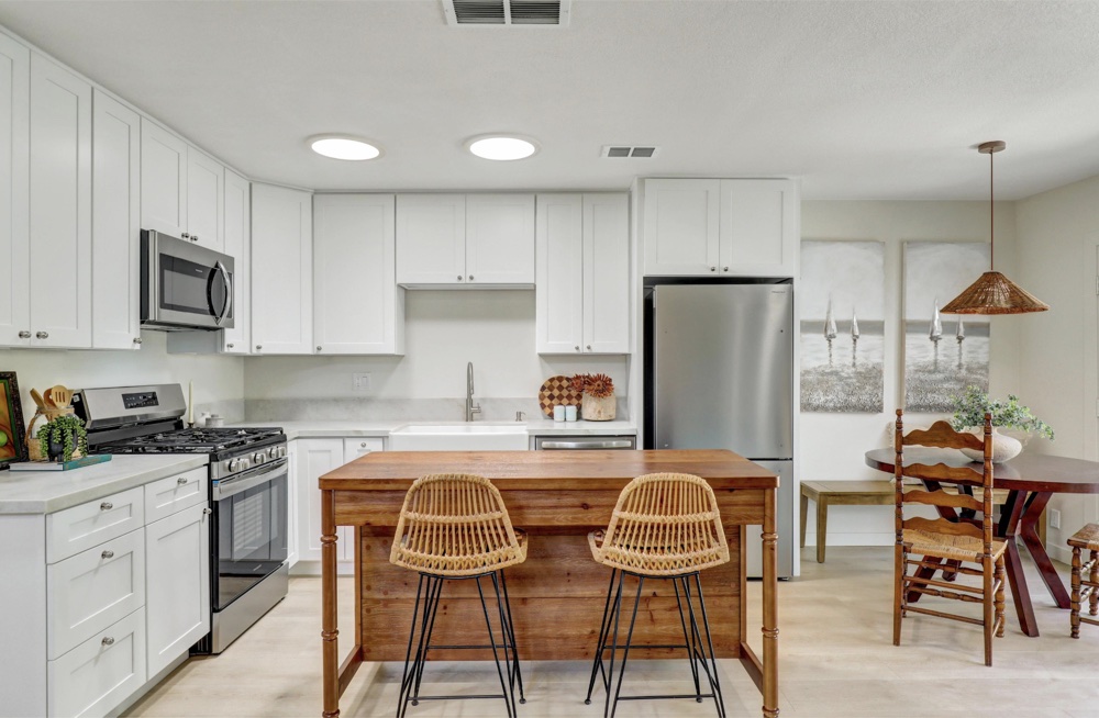 Remodeled kitchen with white cabinets and a window over the sink